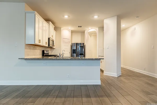 a view of kitchen with granite countertop cabinets and wooden floor