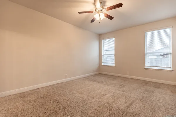 an empty room with windows and fan