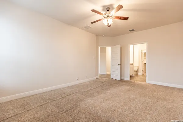 an empty room with a ceiling fan and a window