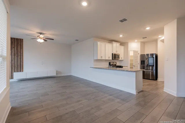 a view of kitchen with refrigerator stove and cabinets