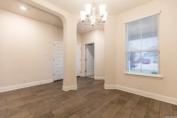 a view of an empty room with wooden floor