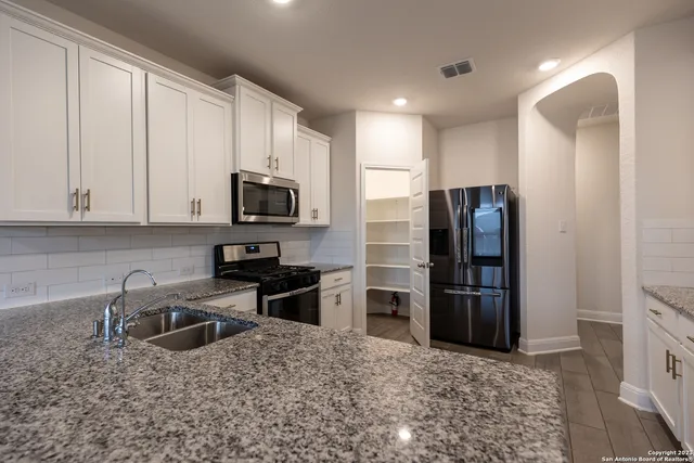 a kitchen with stainless steel appliances granite countertop a refrigerator stove and microwave