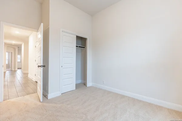 a view of a hallway with wooden floor and closet