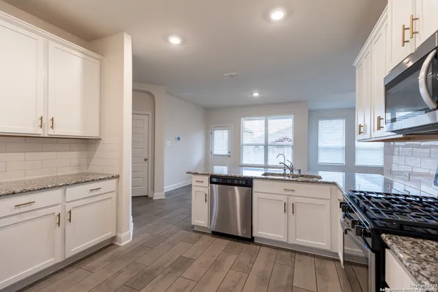 a kitchen with stainless steel appliances granite countertop a stove and a sink