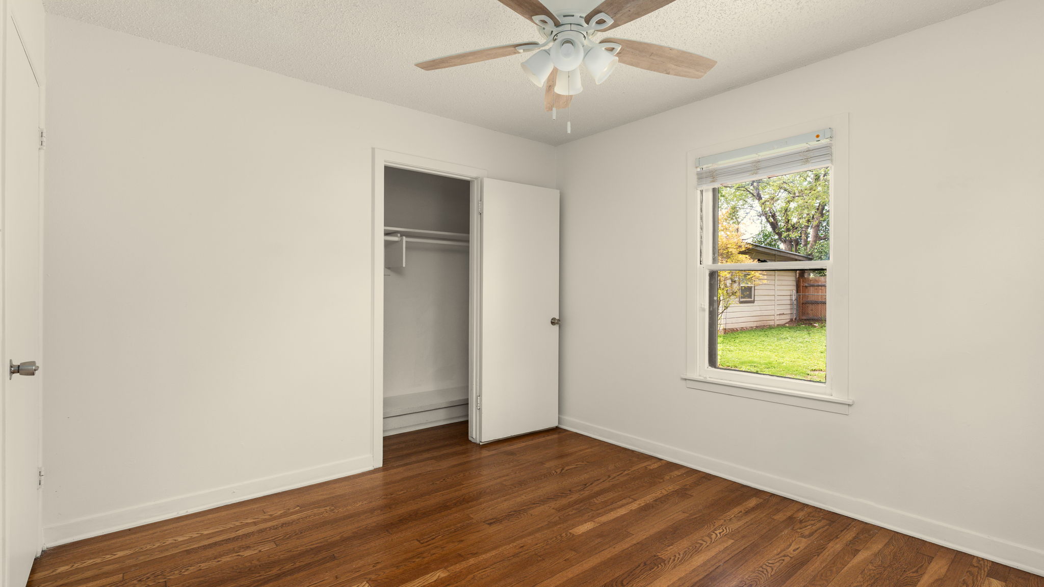 206 East Skyview Road Austin, TX 78752 - Photo 22 of 32 2nd bedroom. Warm hardwood floors and a window view of the tranquil backyard.