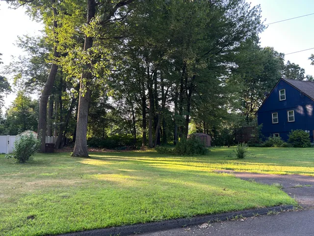 a view of a swimming pool in a yard with lawn chairs