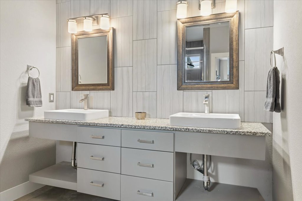 1800 Webberville Road, Unit B Austin, TX 78721 - Photo 16 of 30 Dual vanity with vessel sinks, granite-style countertop, and modern cabinetry