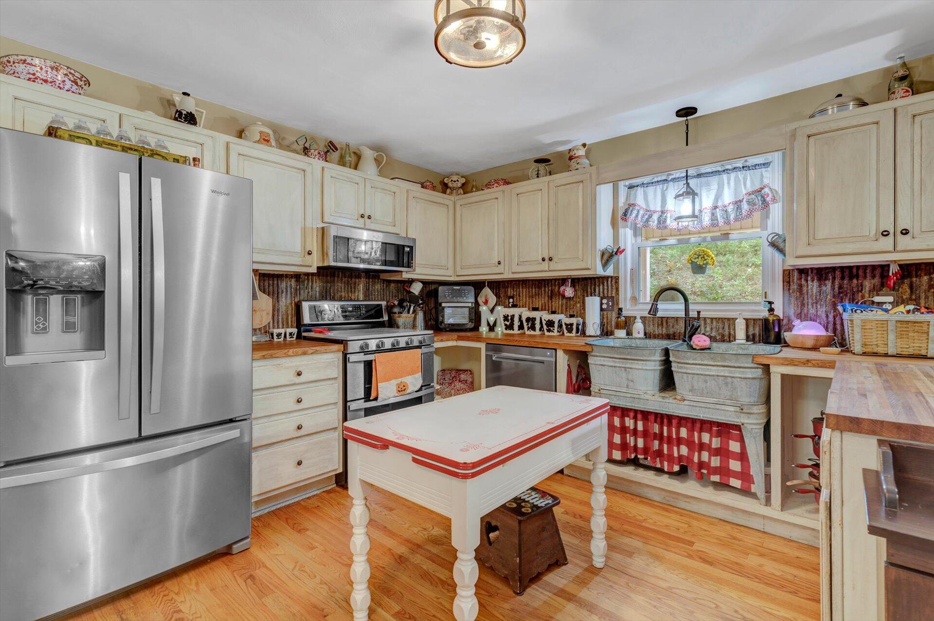 415 Eton Road Hardy, VA 24101 - Photo 15 of 44 a kitchen with stainless steel appliances granite countertop a refrigerator a stove top oven a sink dishwasher and white cabinets with wooden floor