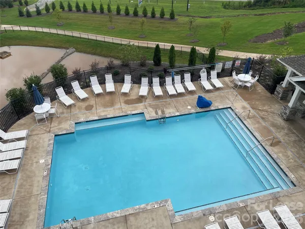 a view of swimming pool with outdoor seating and plants