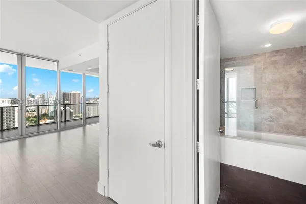 a view of a hallway view with wooden floor and seating space