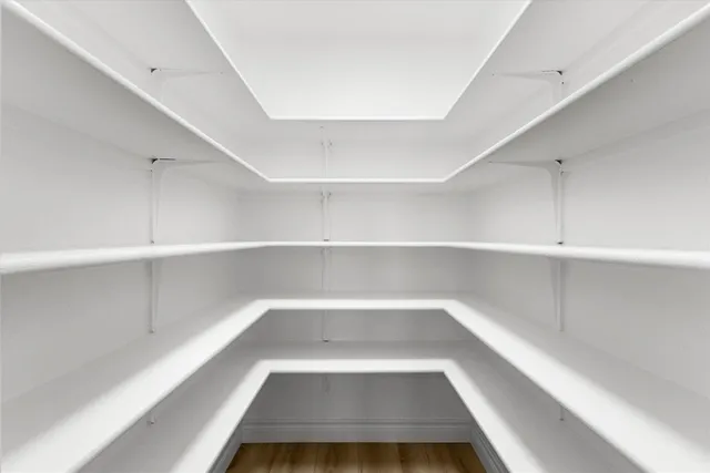 a kitchen with stainless steel appliances granite countertop a refrigerator a sink dishwasher a stove and white countertops with wooden floor