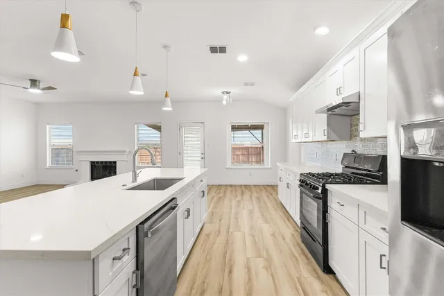 a kitchen with a sink stove and cabinets