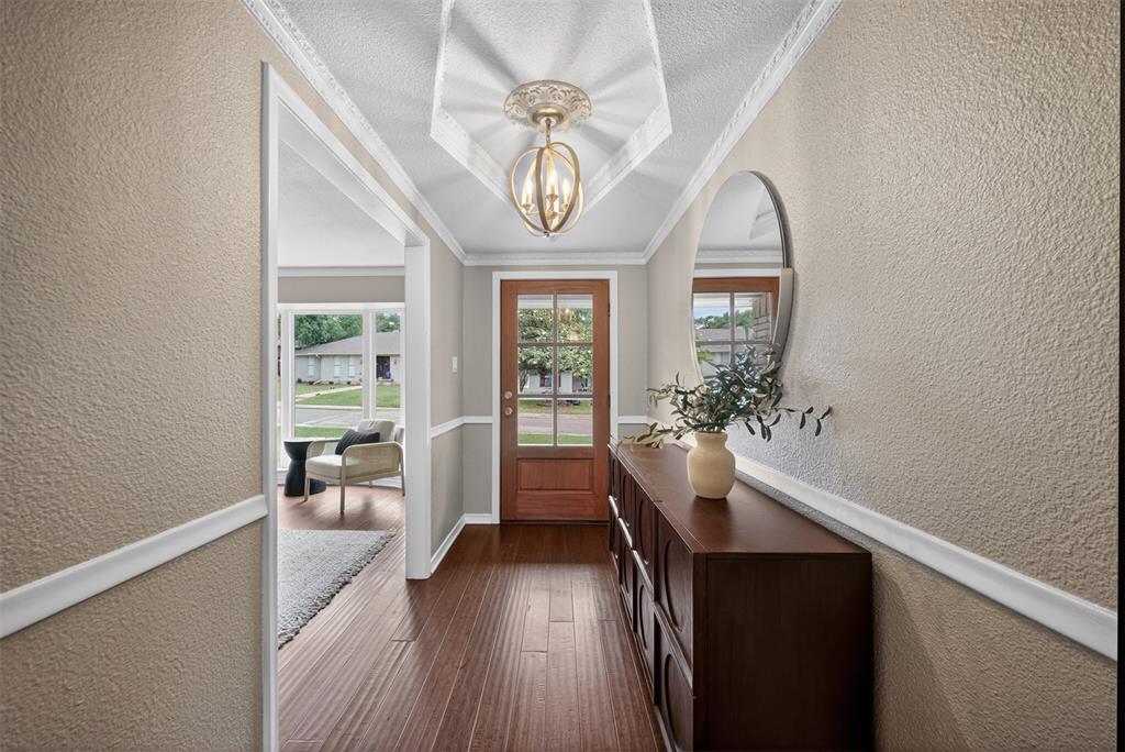 9660 Timberleaf Drive Dallas, TX 75243 - Photo 3 of 40 Entryway featuring wood-finish flooring, a decorative ceiling fixture, and wainscoting