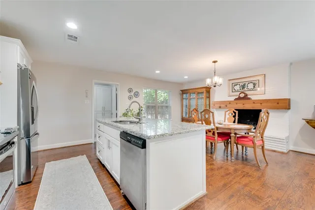 a living room with furniture a fireplace and a dining table with wooden floor