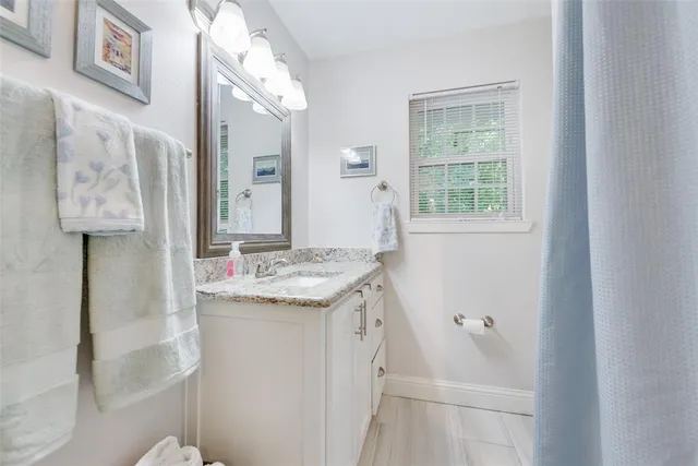a en suite bathroom with a granite countertop sink and a mirror