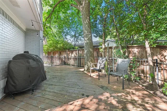 a view of a patio with table and chairs with wooden floor and fence