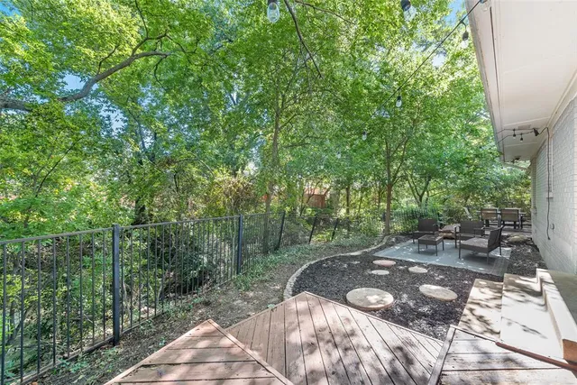a view of a patio with table and chairs and floor to ceiling window