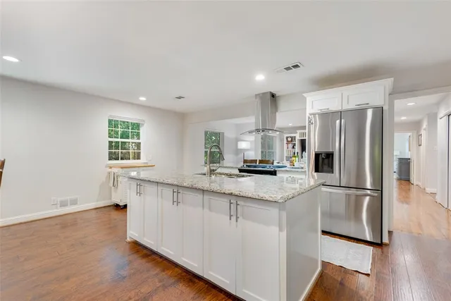 a kitchen with stainless steel appliances a refrigerator and a stove top oven
