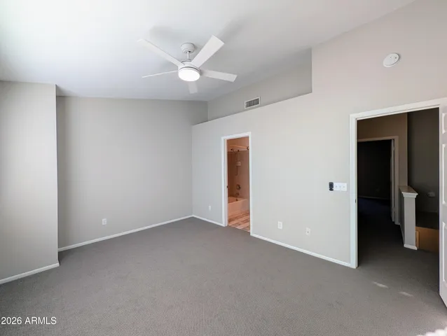 an empty room with closet and a ceiling fan