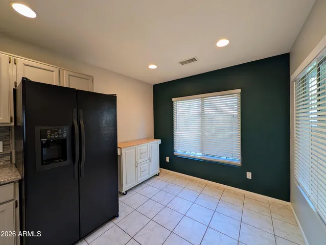 a view of a kitchen with refrigerator and mirror