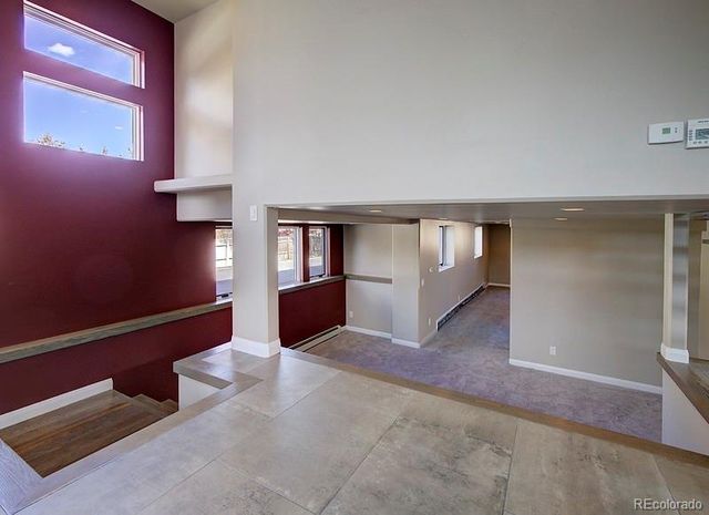 a view of an empty room with window and stairs