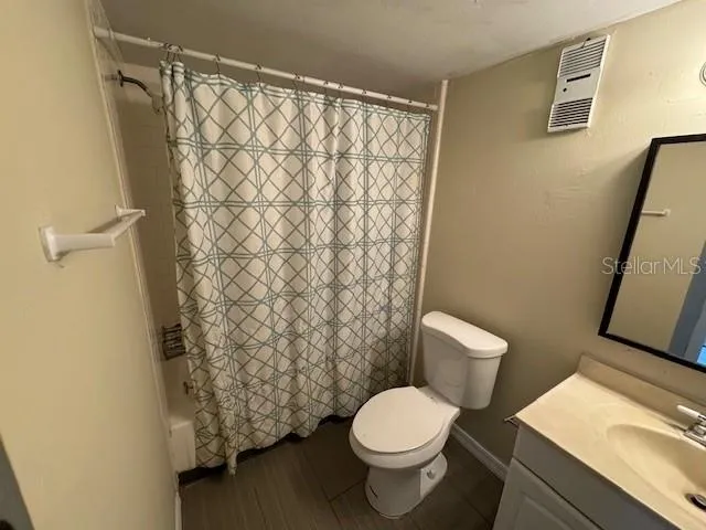 a white toilet sitting next to a shower curtain