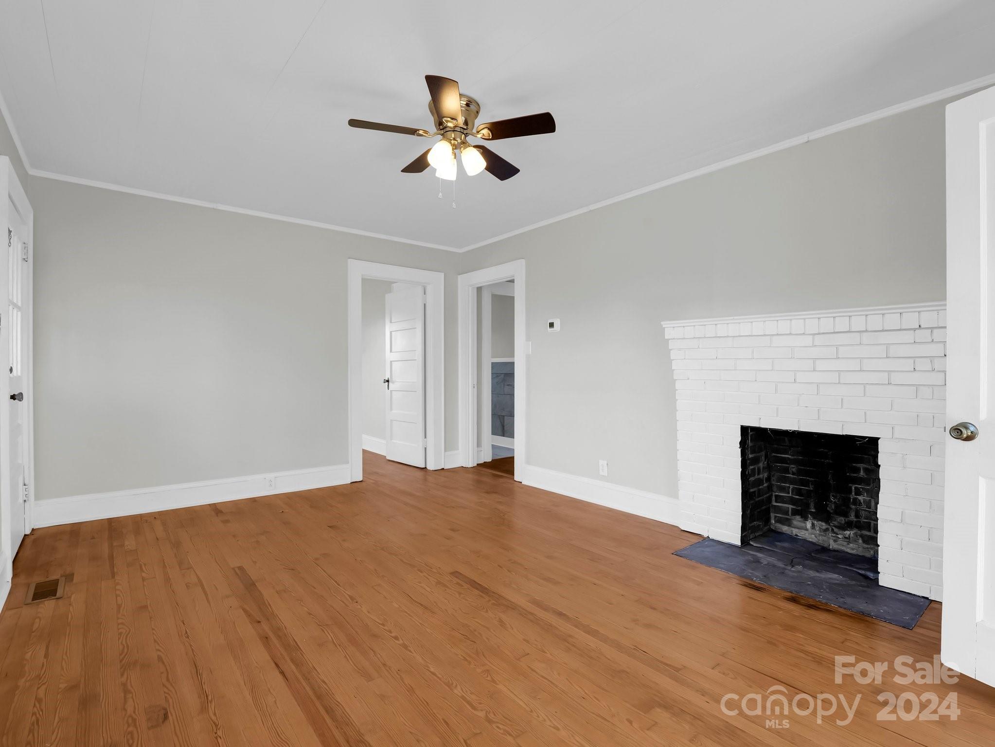 574 Cat Square Road Lincolnton, NC 28092 - Photo 9 of 48 a view of an empty room with wooden floor fireplace and a window