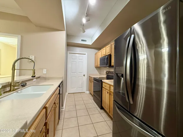 a kitchen with stainless steel appliances a refrigerator sink and microwave