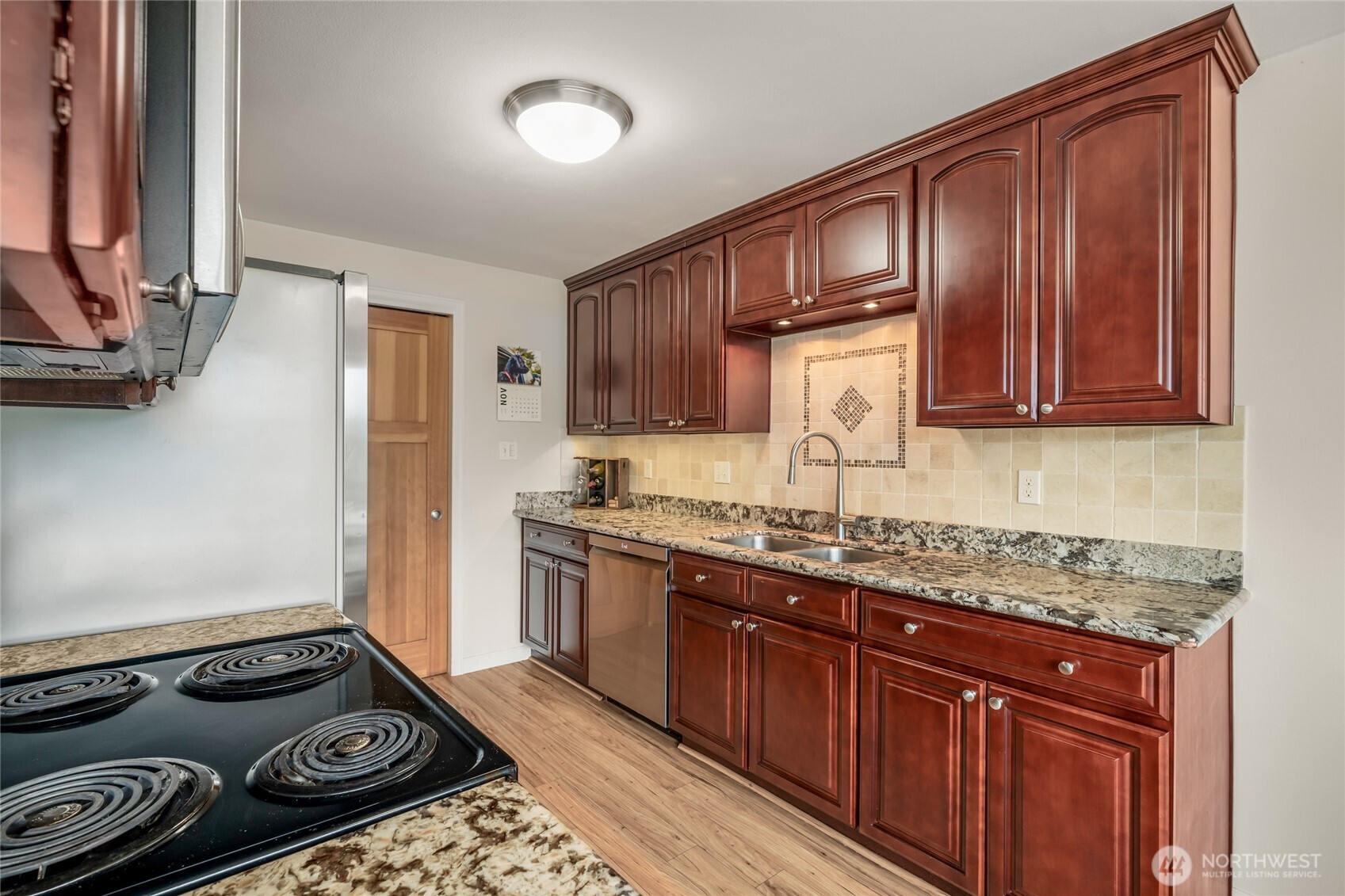 1020 5th Avenue South, Unit 8 Edmonds, WA 98020 - Photo 13 of 28 a kitchen with wooden cabinets and a stove top oven