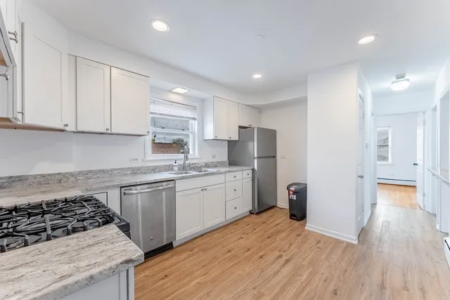 a kitchen with granite countertop a sink stove and refrigerator