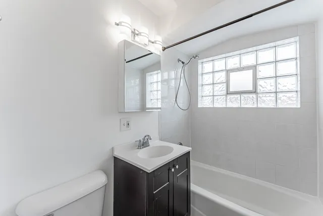 a bathroom with a sink toilet vanity and bathtub