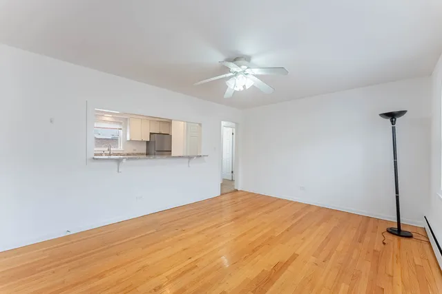a view of a big room with wooden floor and windows