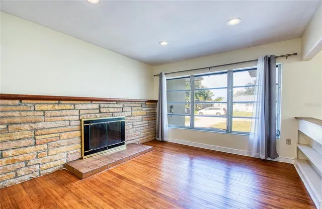 a view of an empty room with a fireplace and a window
