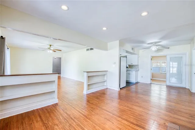 a view of empty room with wooden floor and fireplace