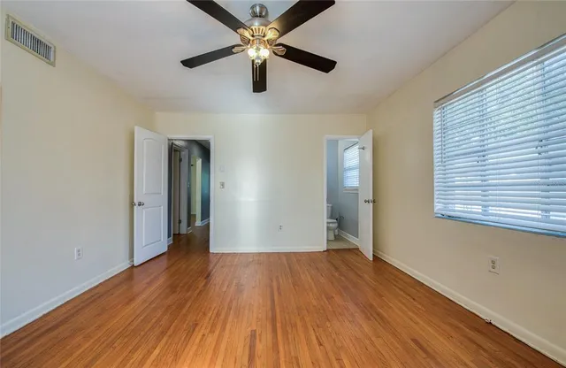 a view of empty room with wooden floor