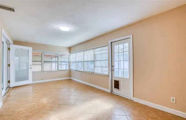 an empty room with a fireplace and windows