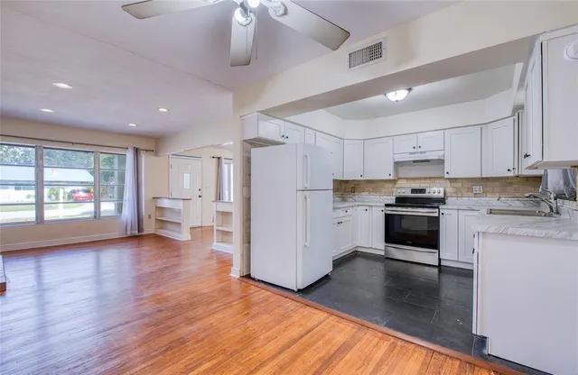a kitchen with granite countertop white cabinets and a sink
