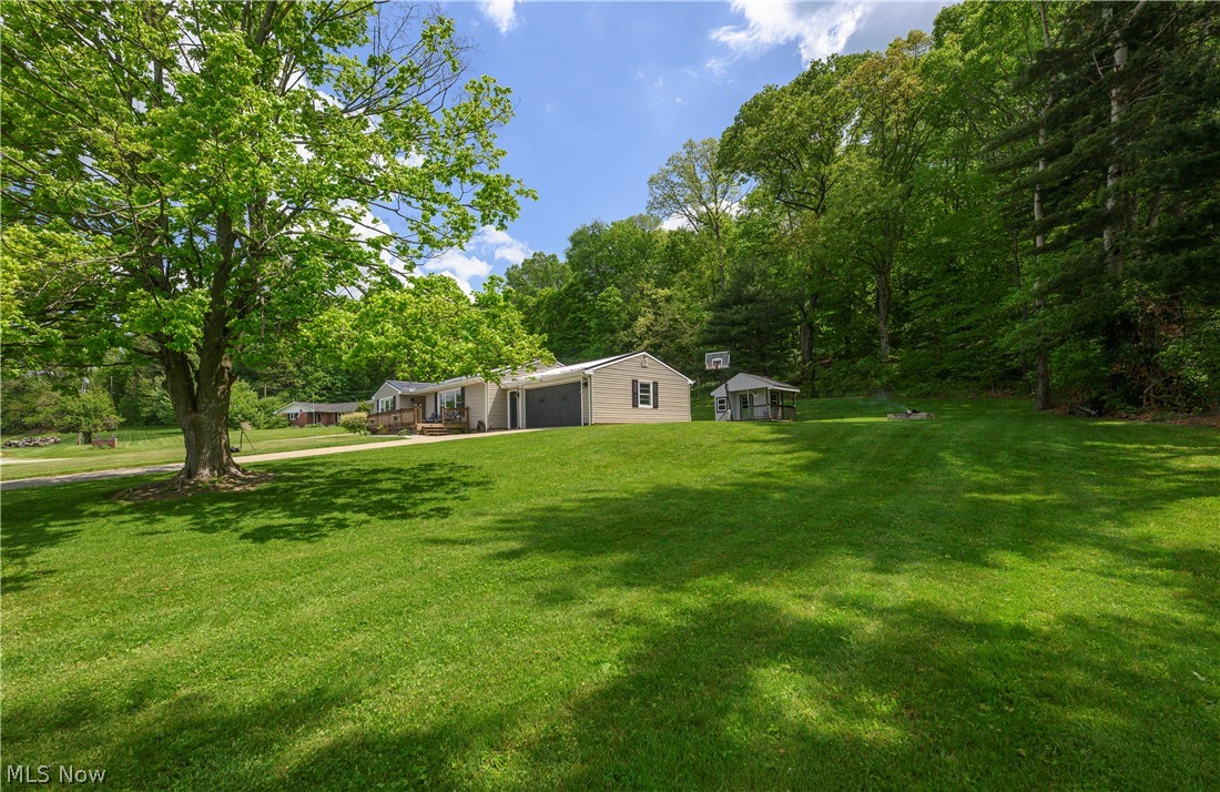 6105 Wolf Run Road Southeast Dennison, OH 44621 - Photo 3 of 35 Expansive green lawn with mature trees and a wooded backdrop