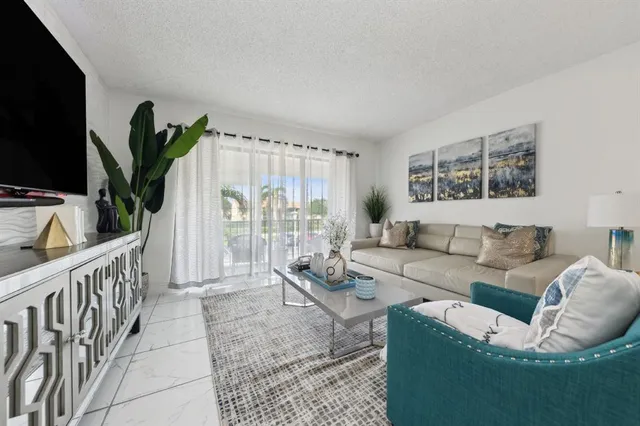 a living room with furniture a flat screen tv and a large window