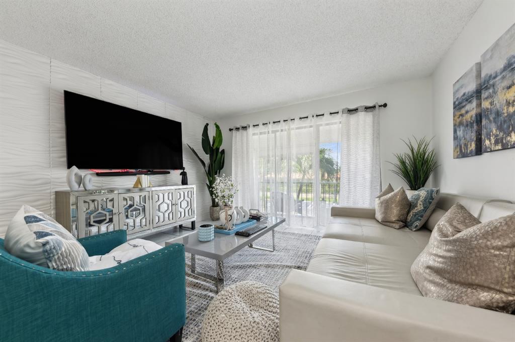 608 Sea Pine Way, Unit D2 Greenacres, FL 33415 - Photo 2 of 13 a living room with furniture and a flat screen tv