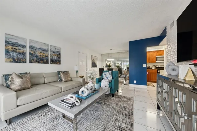 a living room with furniture a flat screen tv and a window