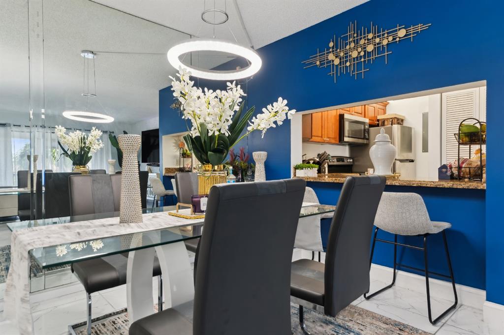 608 Sea Pine Way, Unit D2 Greenacres, FL 33415 - Photo 4 of 13 a living room with furniture a chandelier and a piano