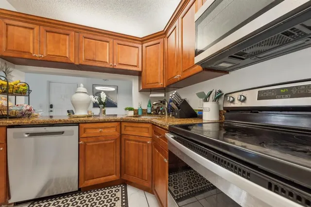 a kitchen with granite countertop a stove and cabinets
