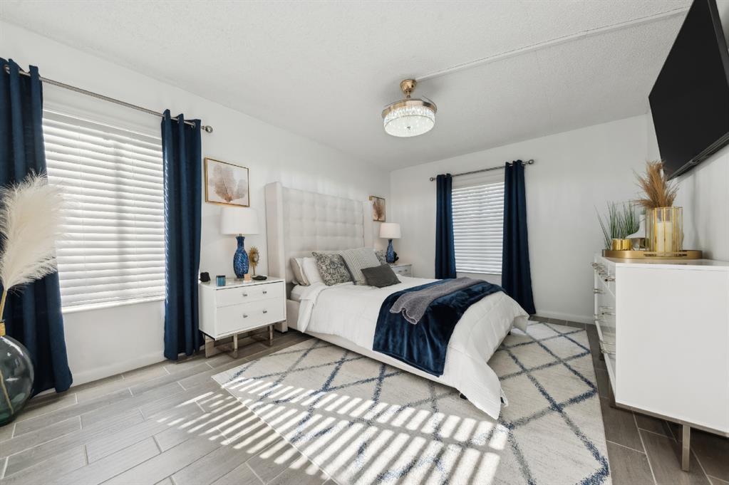 608 Sea Pine Way, Unit D2 Greenacres, FL 33415 - Photo 7 of 13 a bedroom with a bed and a flat screen tv