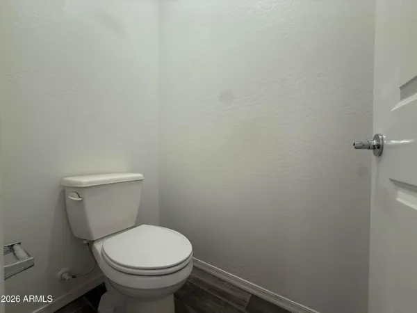 a white toilet sitting next to a white wall