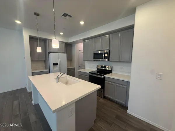 a kitchen with a refrigerator a sink and a stove top oven
