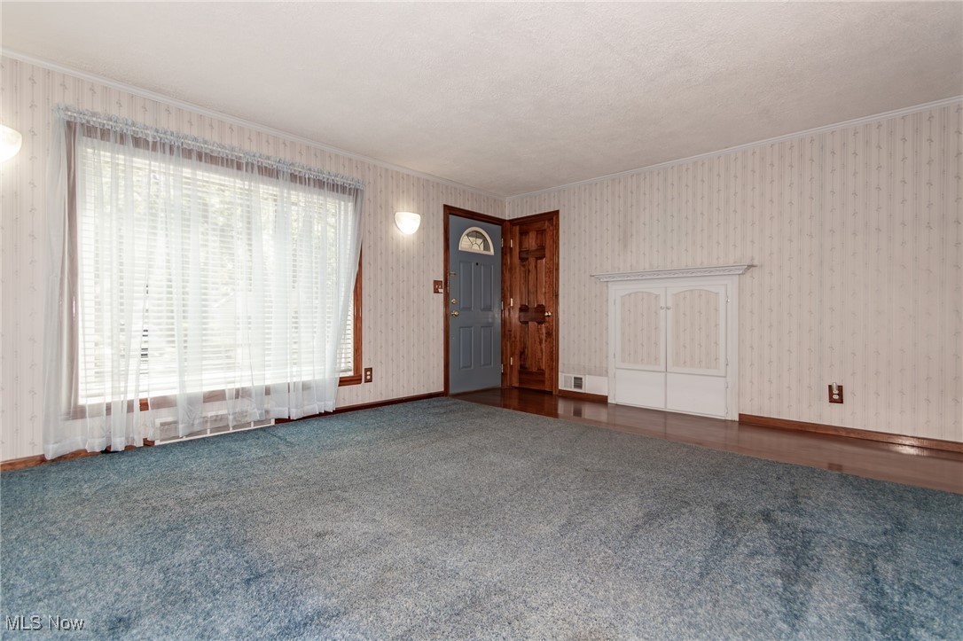 5223 Edenhurst Road Cleveland, OH 44124 - Photo 3 of 50 Unfurnished living room with crown molding, carpet floors, and wallpapered walls