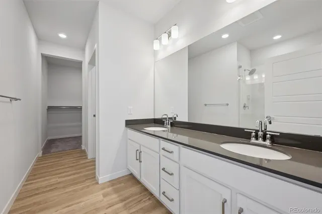 a bathroom with double vanity sinks and a mirror