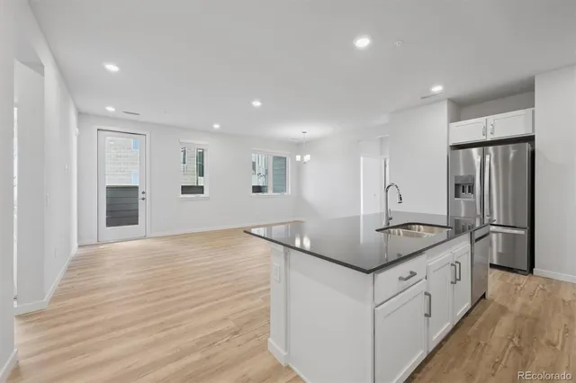 a kitchen with stainless steel appliances granite countertop a sink and a refrigerator
