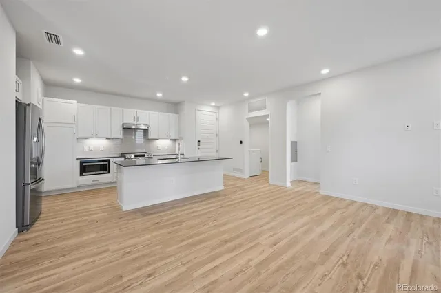 a large kitchen with kitchen island a sink stainless steel appliances and cabinets